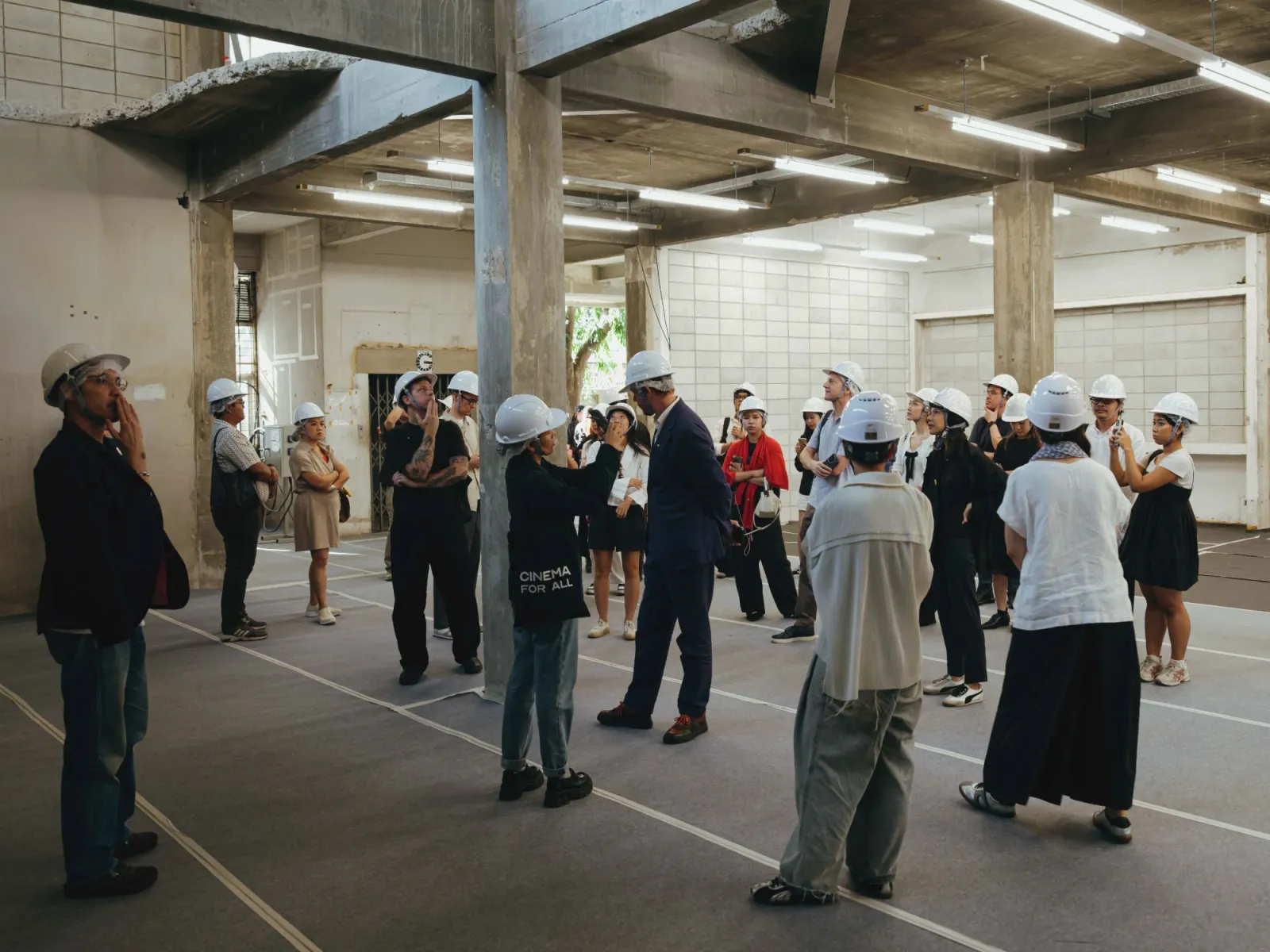 Journalists in hard hats touring the former Central Garment Factory in Phra Khanong